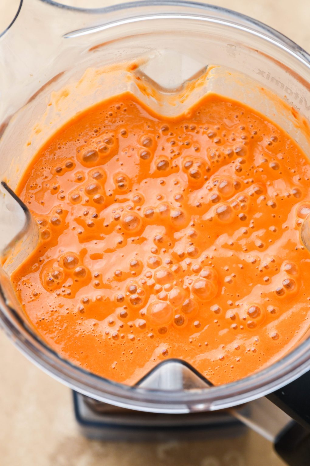 Creamy bright orange gazpacho after blending inside Vitamix container.