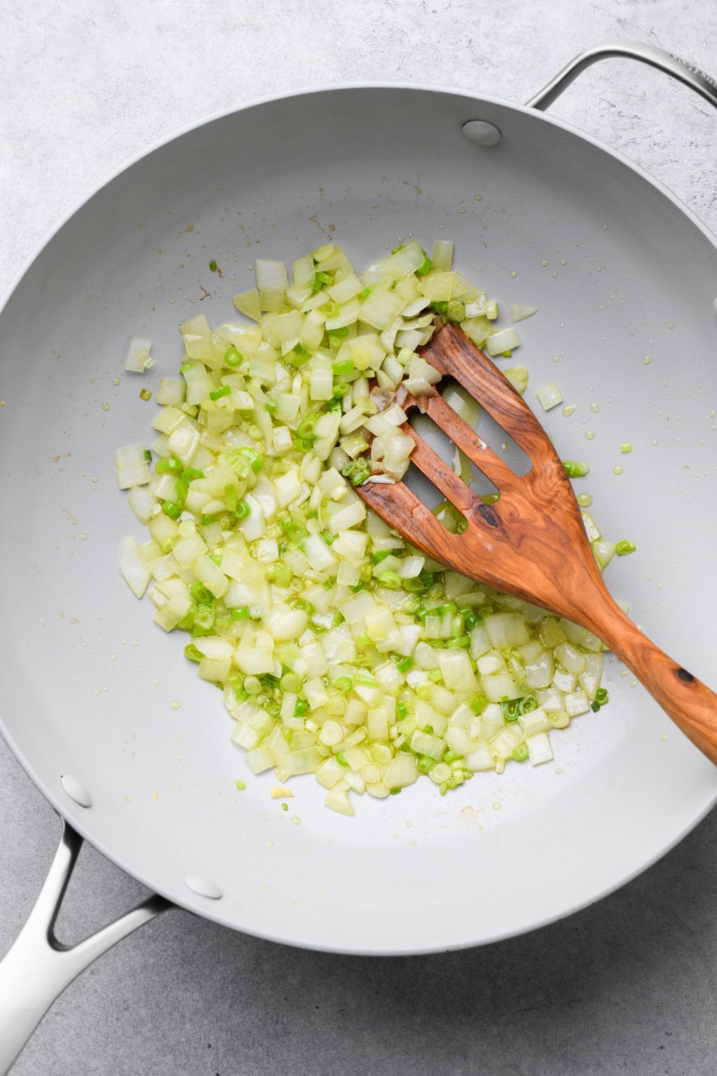 Wok with cooked diced green onions and thinly sliced green onions.