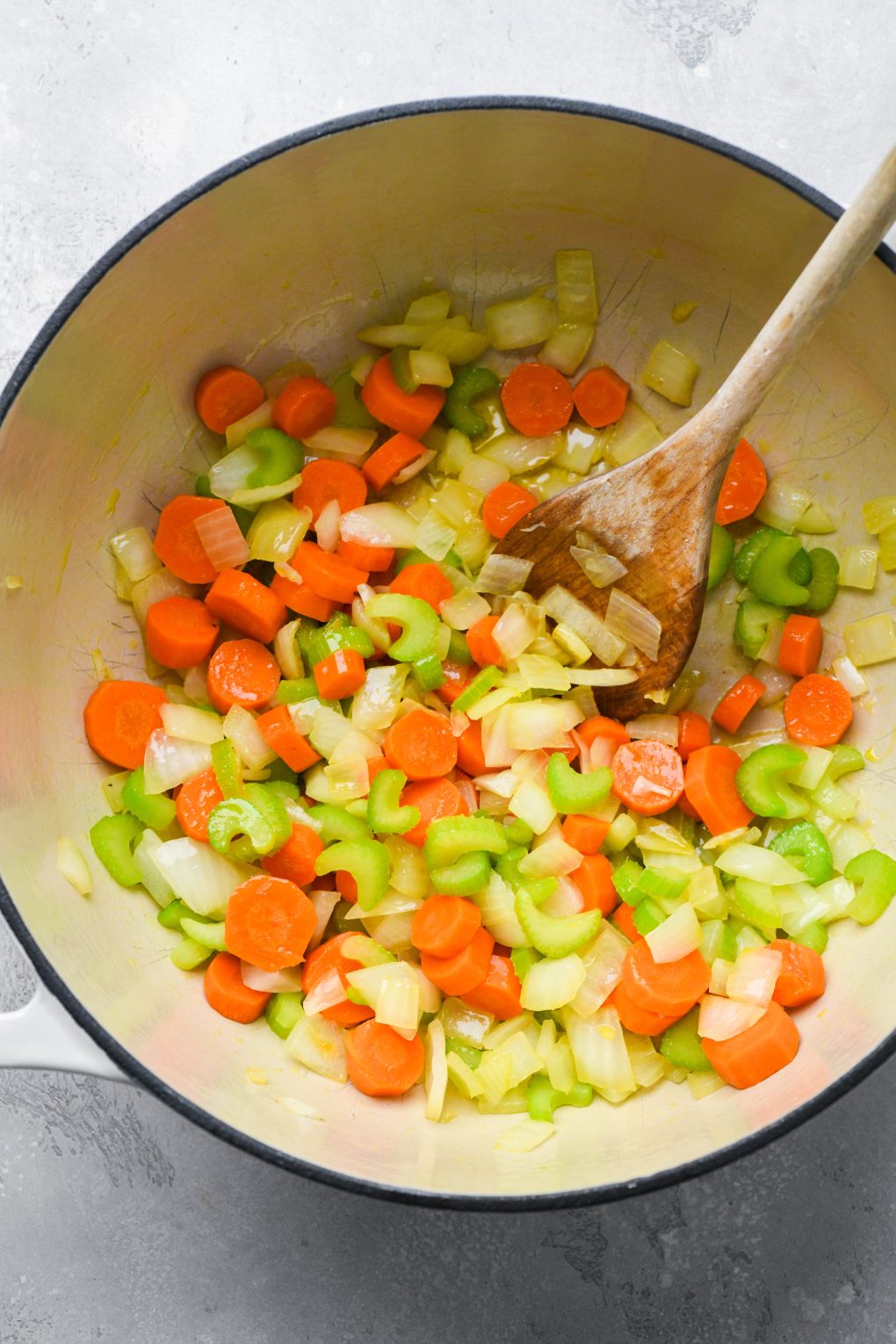 How to make anti inflammatory vegetable soup - Diced onions, carrots, and celery sauteed in a large ceramic soup pot with olive oil. 