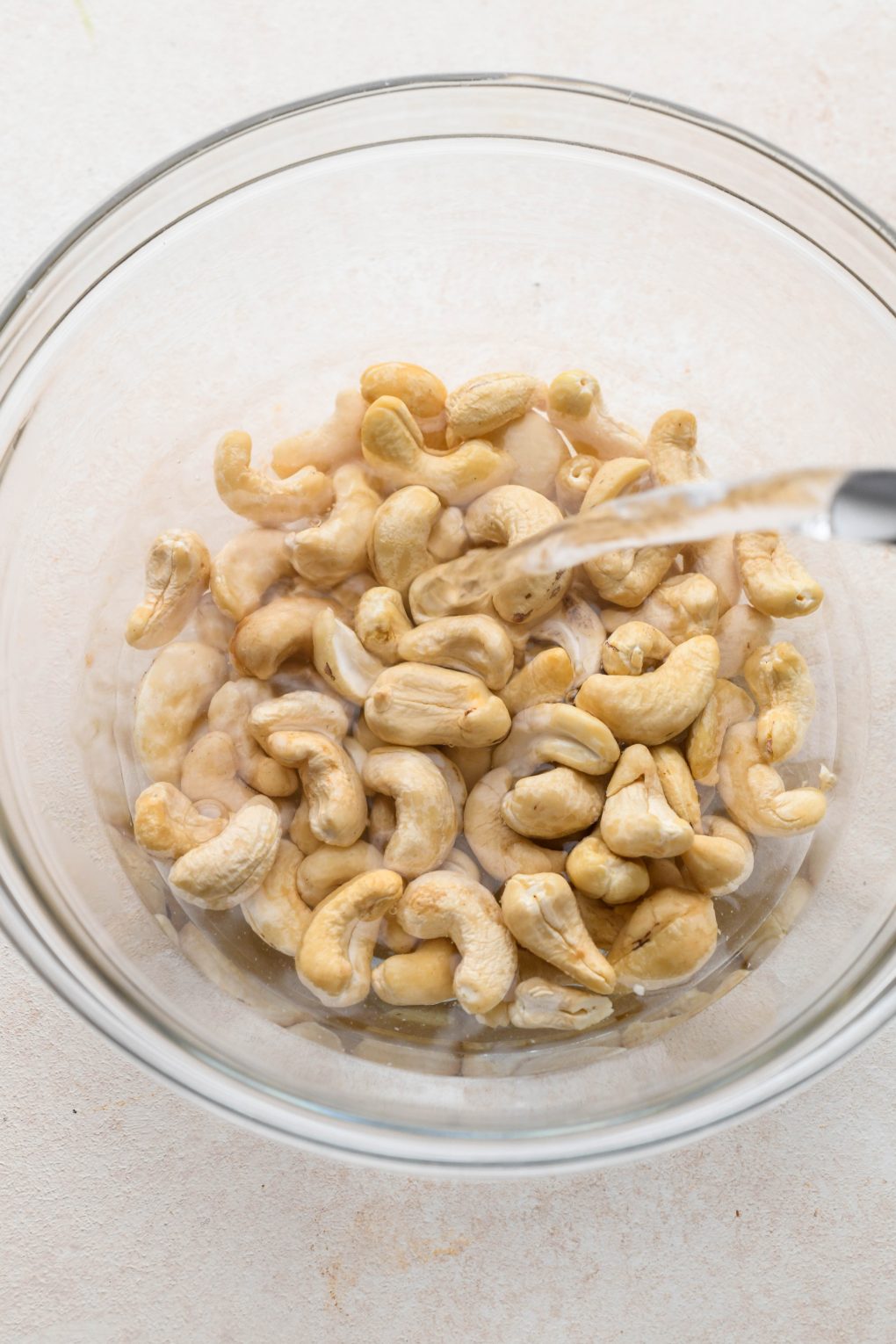 How to make healthy chicken sausage pasta: soaking raw cashews in hot water.