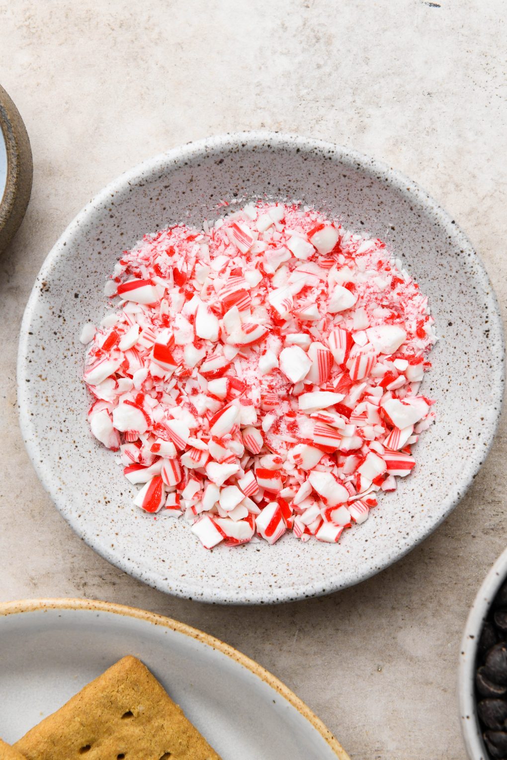 Ingredients images for chocolate peppermint covered graham crackers: Small bowl of crushed candy canes.