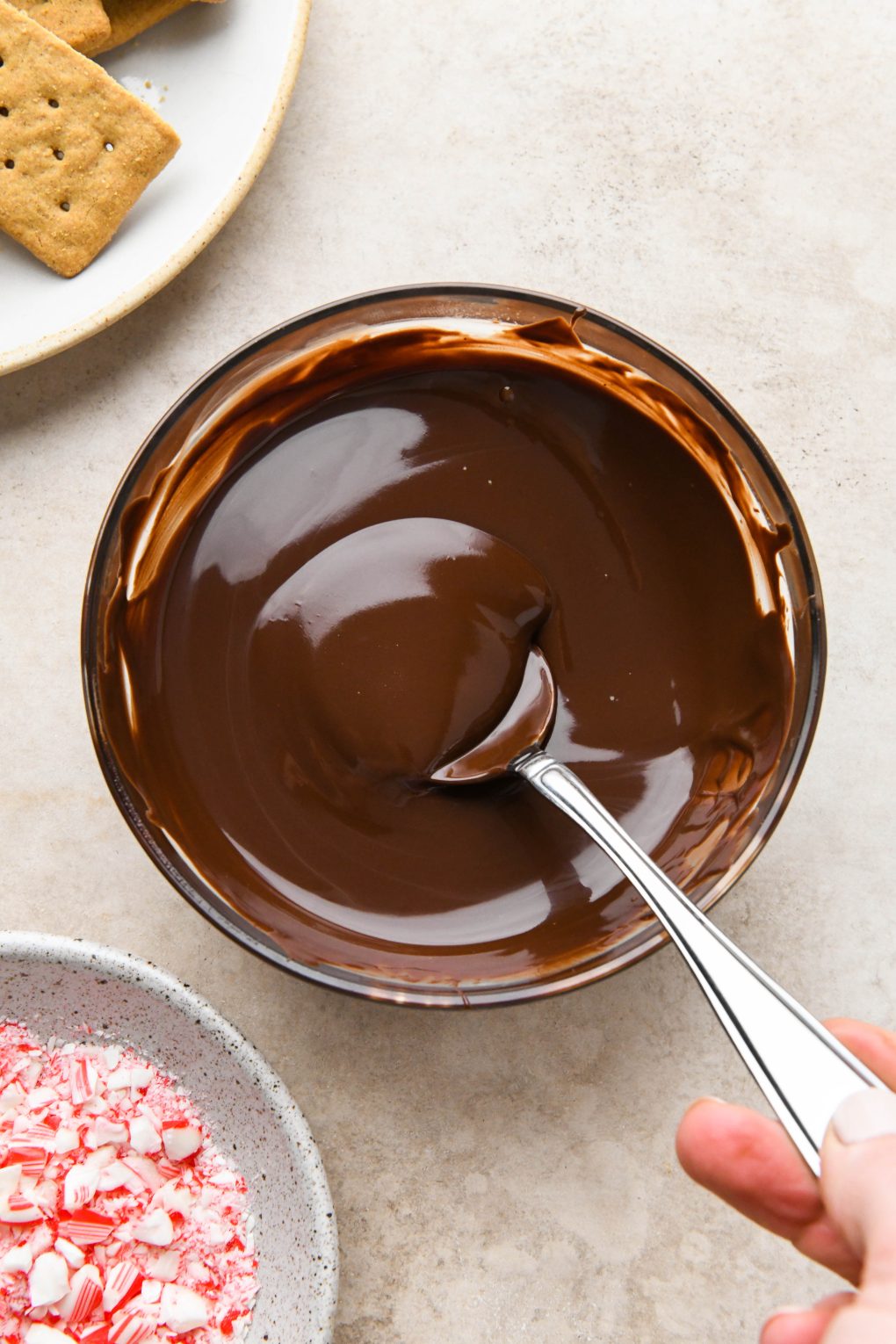 A small glass bowl of melted chocolate for dipping graham crackers.