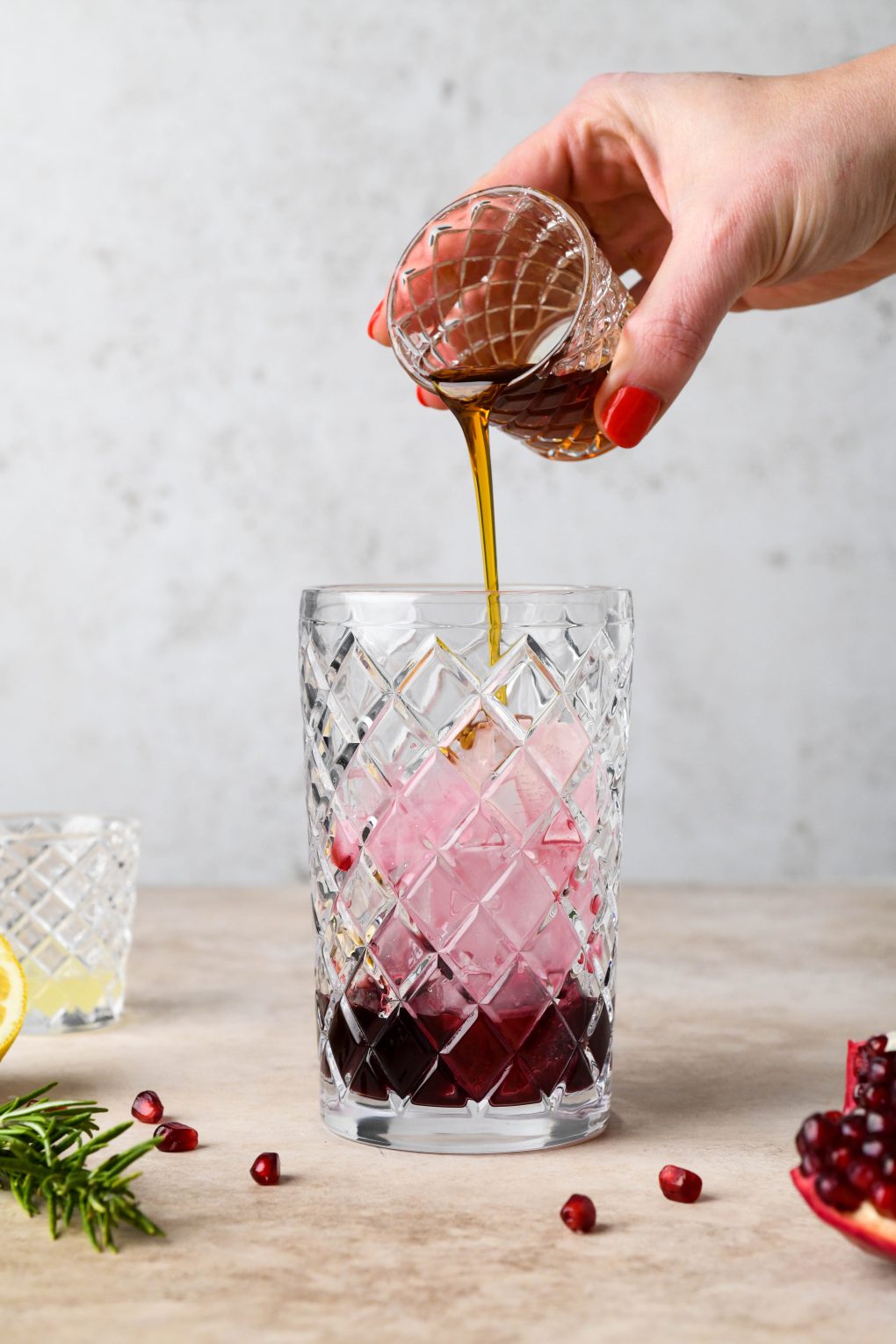 How to make Festive Pomegranate Champagne Cocktail: Pouring the maple syrup into cocktail shaker.
