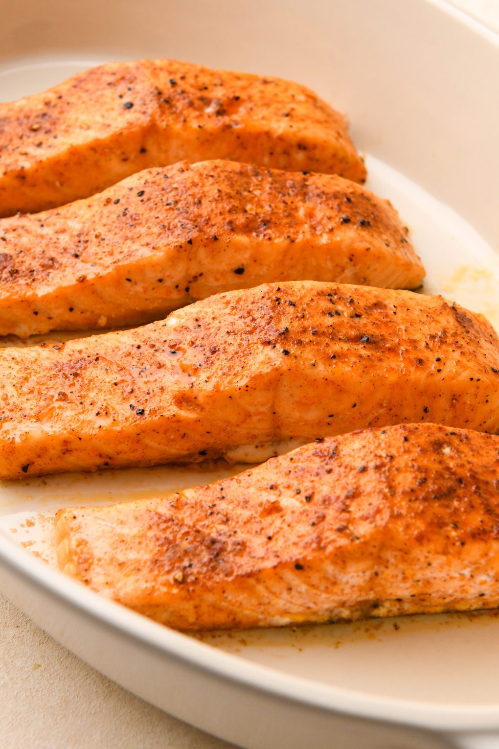 How to make maple pecan glazed salmon: Cooked seasoned salmon fillets in a ceramic baking dish. 