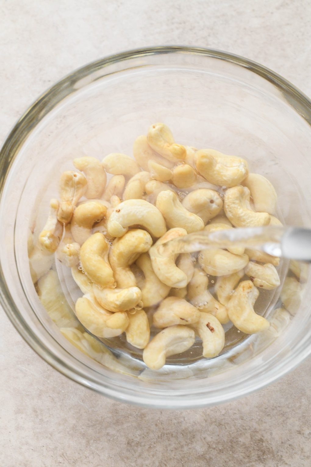How to make creamy vegan mushroom stroganoff: Pouring hot water over cashews for cashew cream sauce.