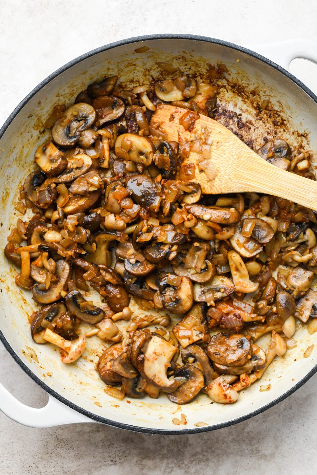 How to make creamy vegan mushroom stroganoff: Cooked mushrooms, onions, and garlic, mixed with spices.