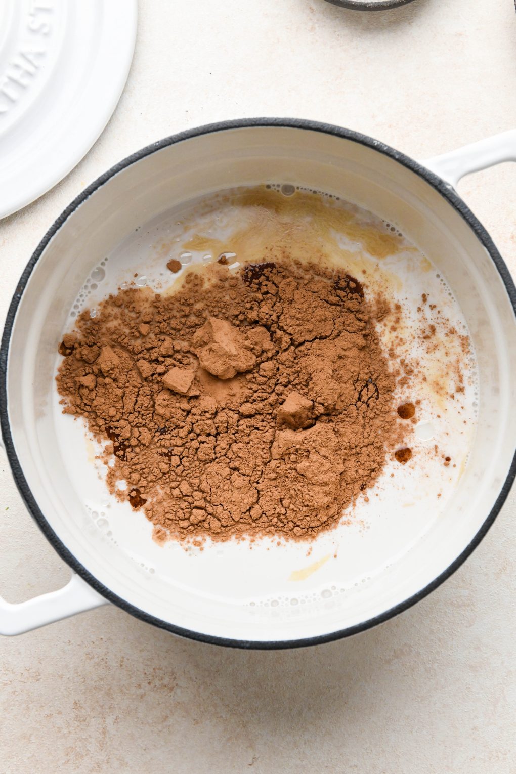 How to make peppermint hot chocolate. Milk, extracts, and cacao powder in small sauce pan.