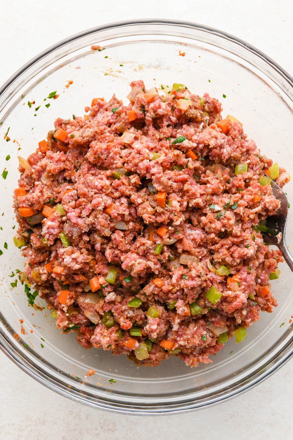 How to make classic Whole30 meatloaf: All ingredients mixed together in a large glass bowl.