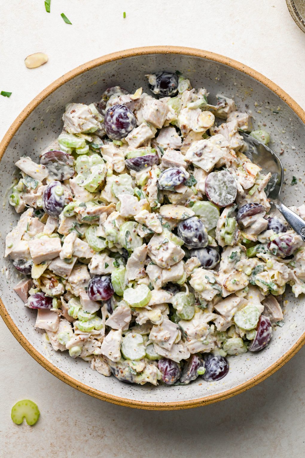 How to make easy chicken salad with grapes: ingredients for chicken salad with grapes in a large ceramic speckled bowl after mixing