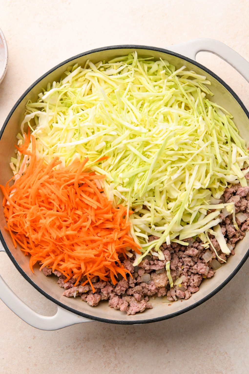 How to make Egg Roll in a Bowl: Shredded cabbage and carrots added to the skillet.