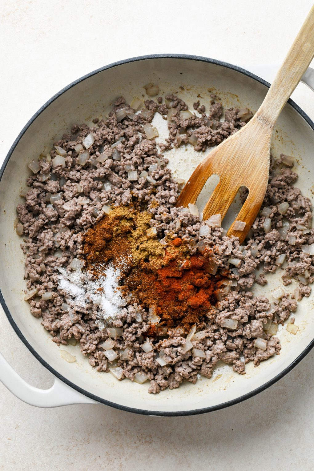 How to make Dairy Free Queso Fundido with Ground Beef: Cooked ground beef and onion in skillet with spices on top.