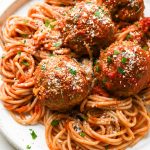 Gluten free meatballs on top of twirled gluten free spaghetti that has been tossed in marinara sauce. Topped with grated parmesan and fresh parsley.