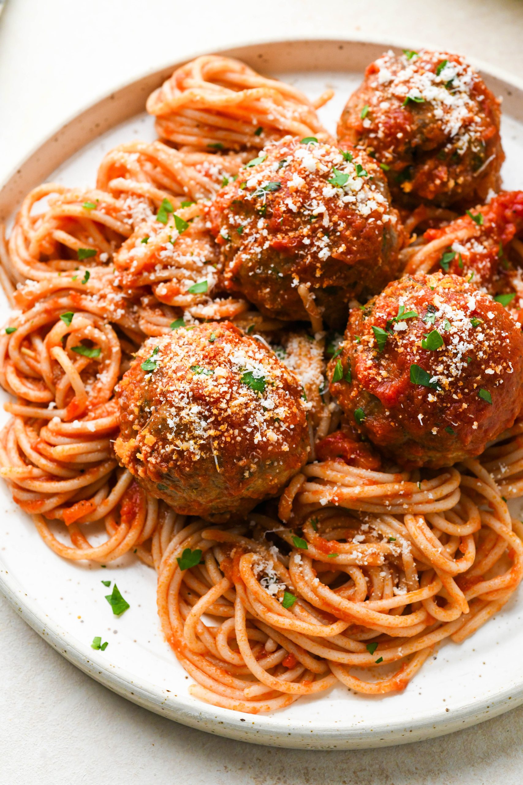 Gluten free meatballs on top of twirled gluten free spaghetti that has been tossed in marinara sauce. Topped with grated parmesan and fresh parsley.