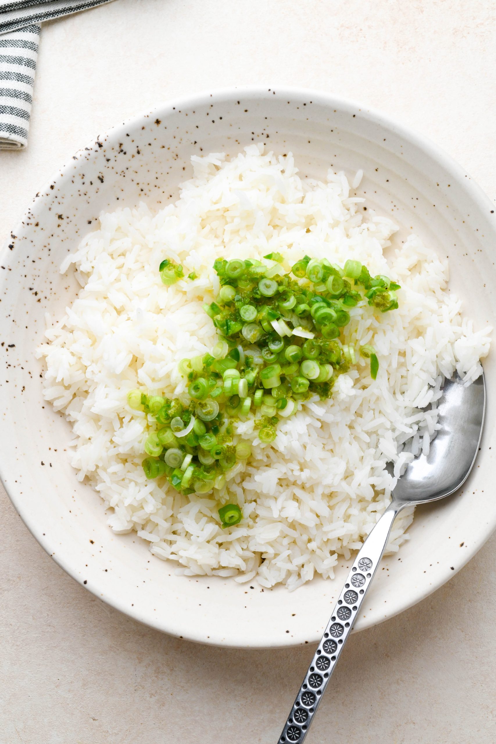 How to make cilantro lime rice: White rice in a large bowl topped with olive oil and lime mixture. 