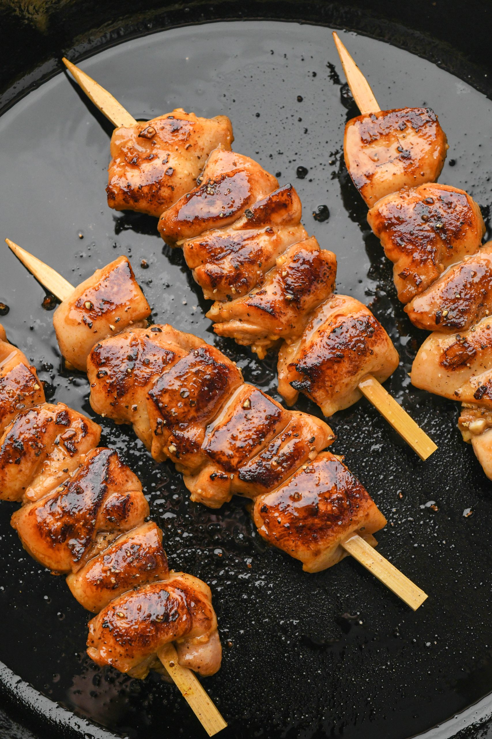 How to make garlic ginger chicken skewers: Chicken skewers seared in a cast iron skillet.