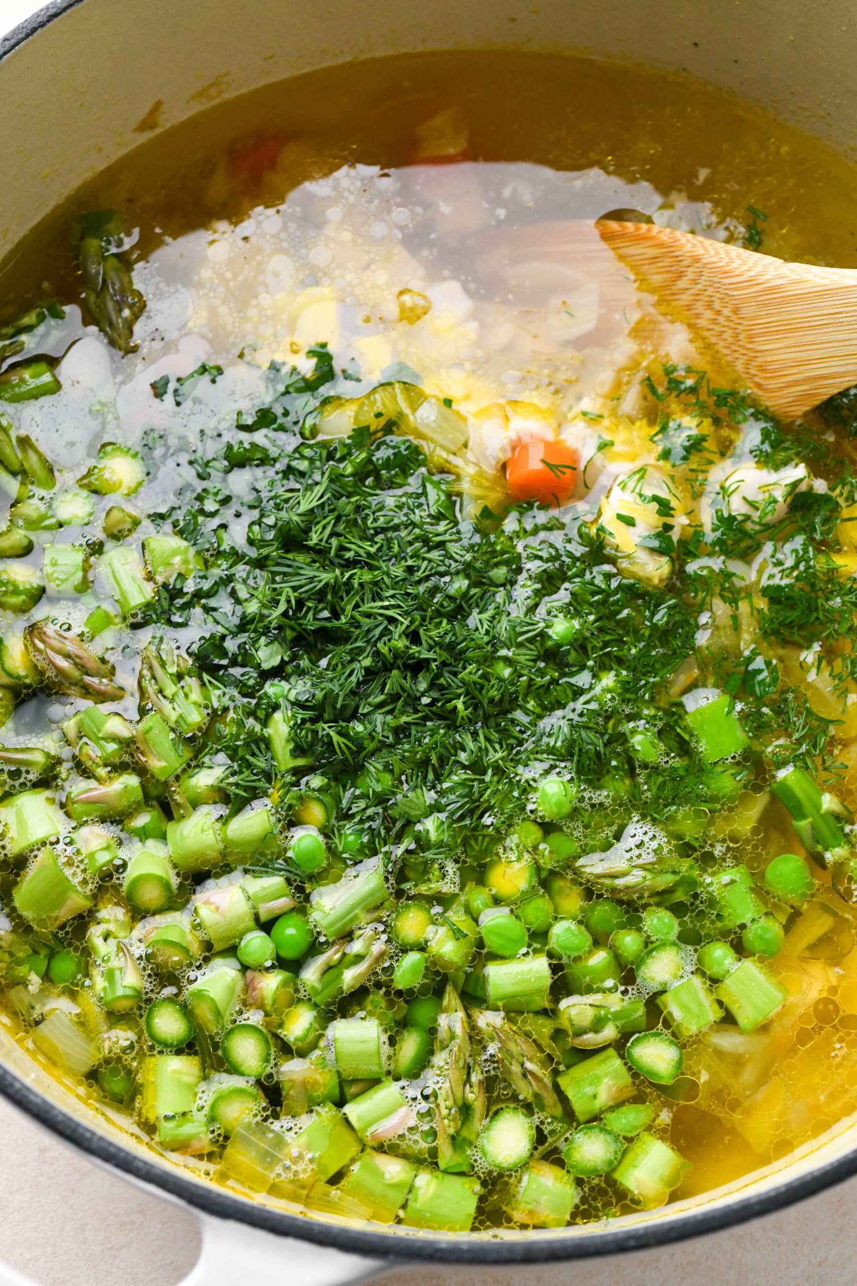 How to make chicken soup with spring vegetables: Diced chicken returned to the pot along with peas, asparagus, and fresh herbs.