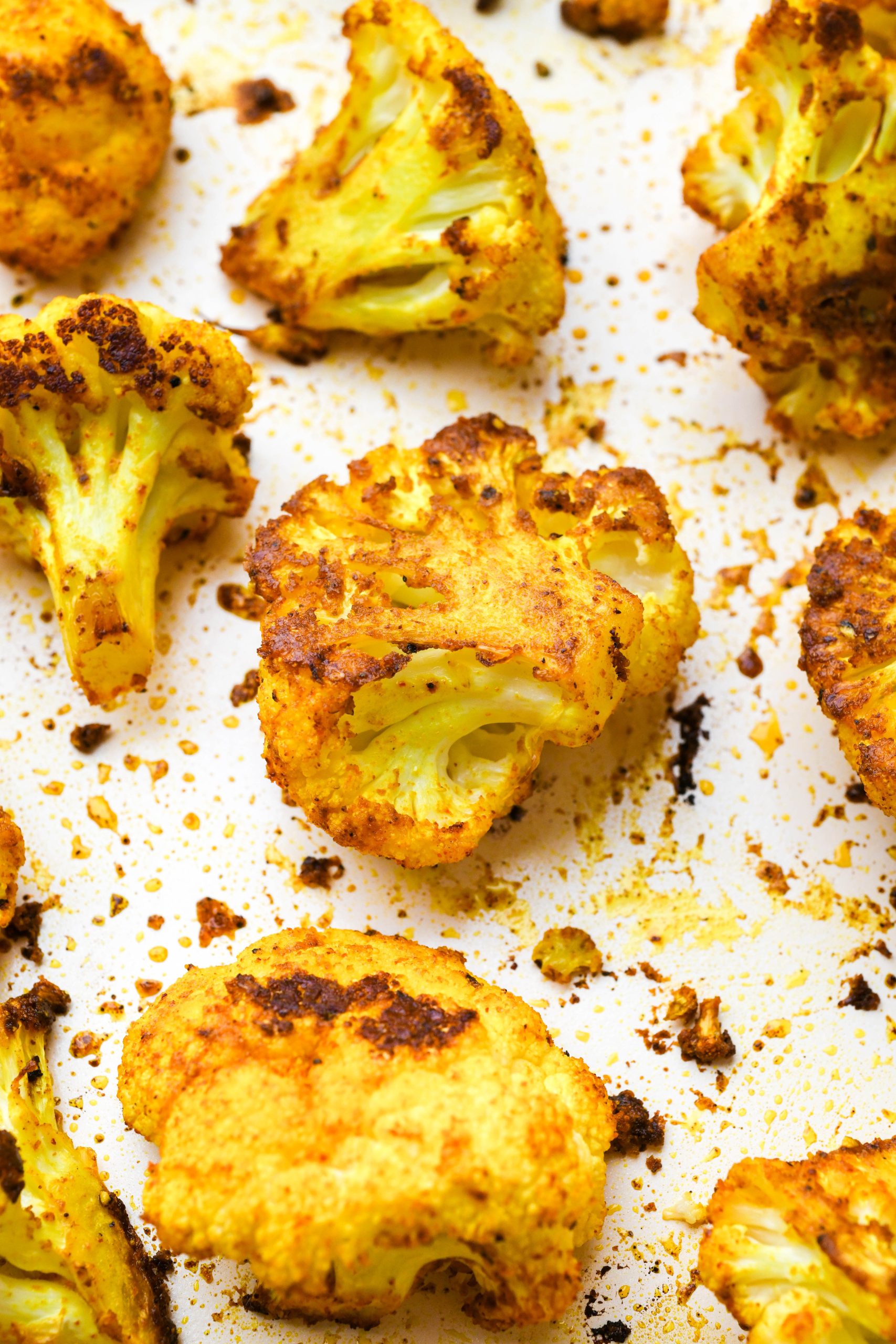 How to make Turmeric Roasted Cauliflower: Close up of cauliflower florets tossed with oil and spices after roasting.