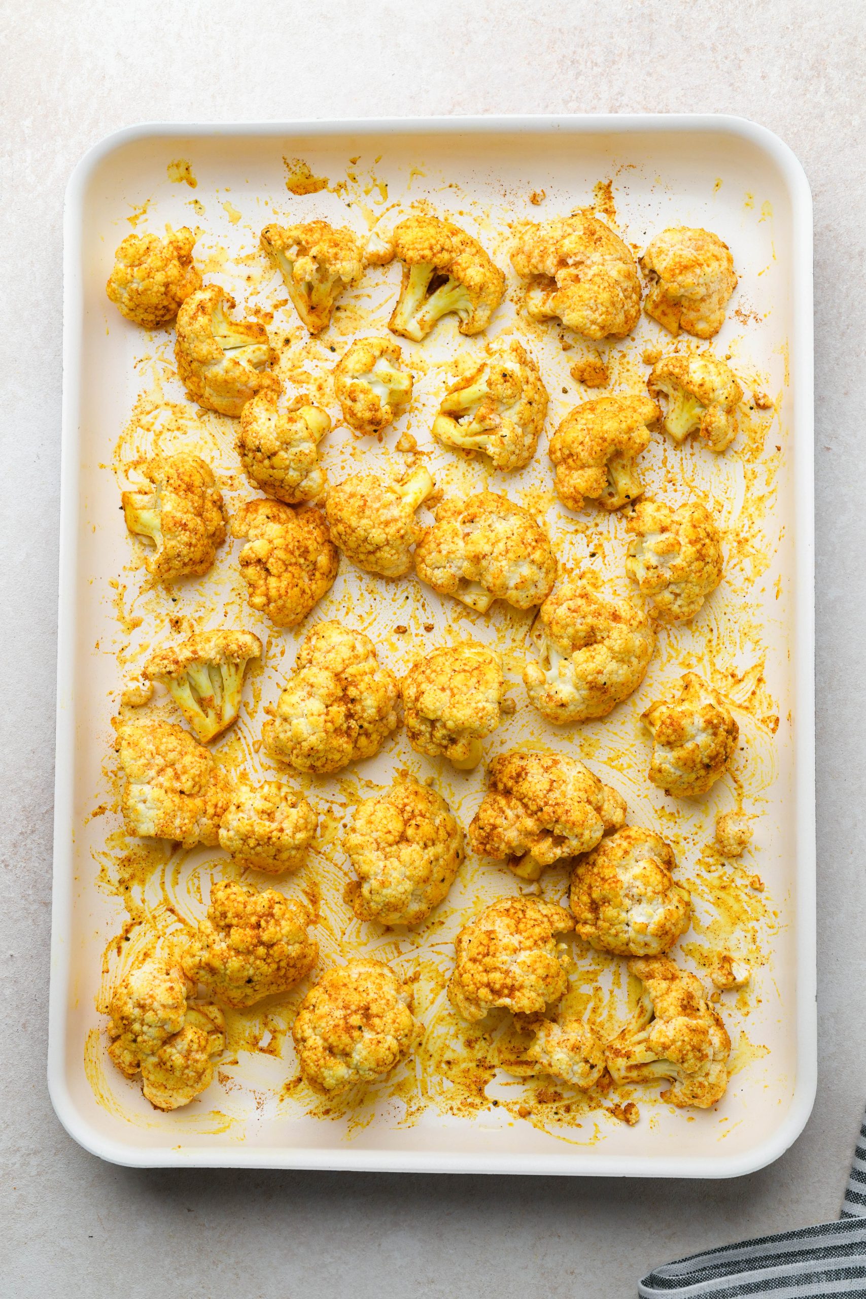 How to make Turmeric Roasted Cauliflower: Raw cauliflower florets tossed with oil and spices before roasting.