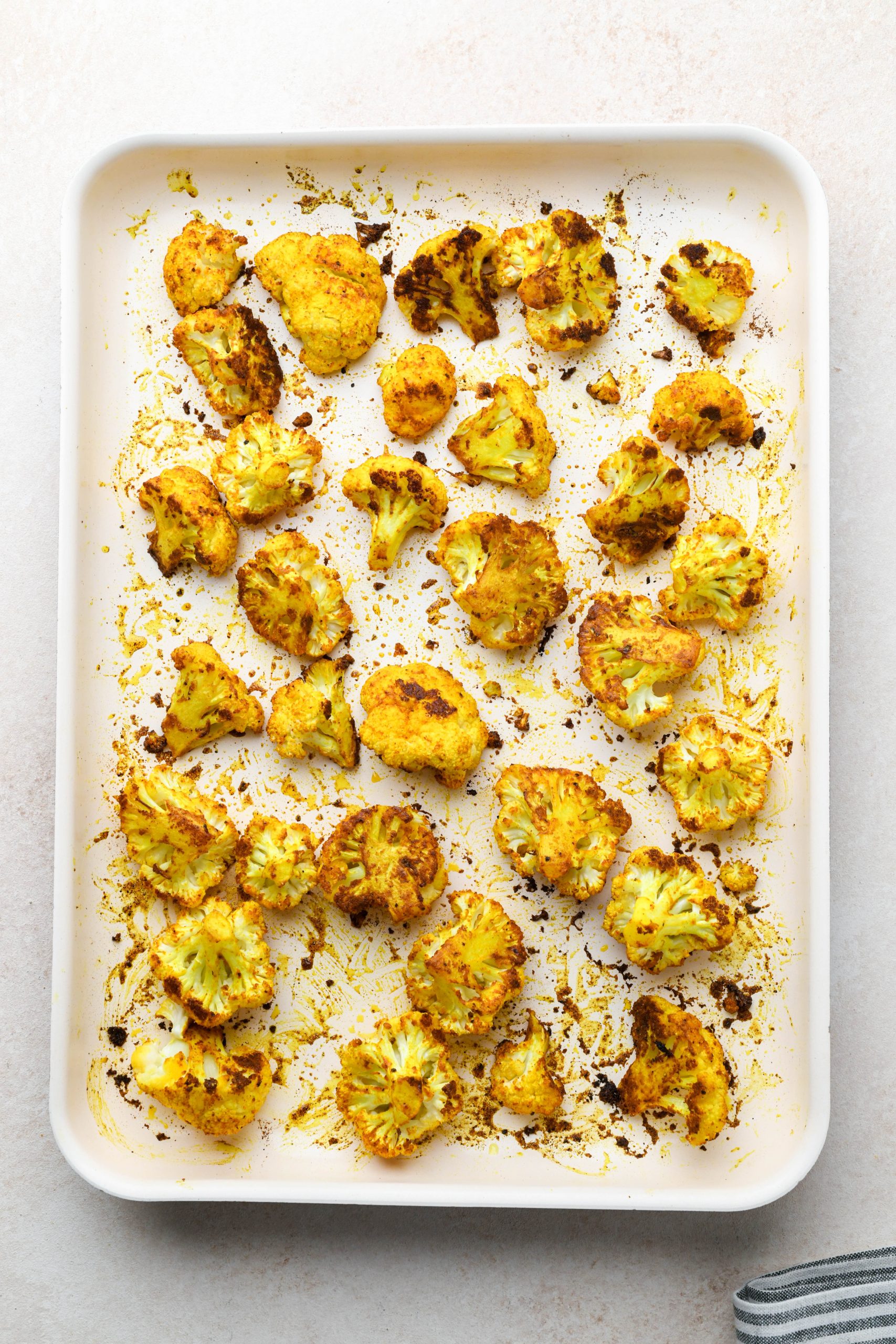 How to make Turmeric Roasted Cauliflower: Cauliflower florets tossed with oil and spices after roasting.
