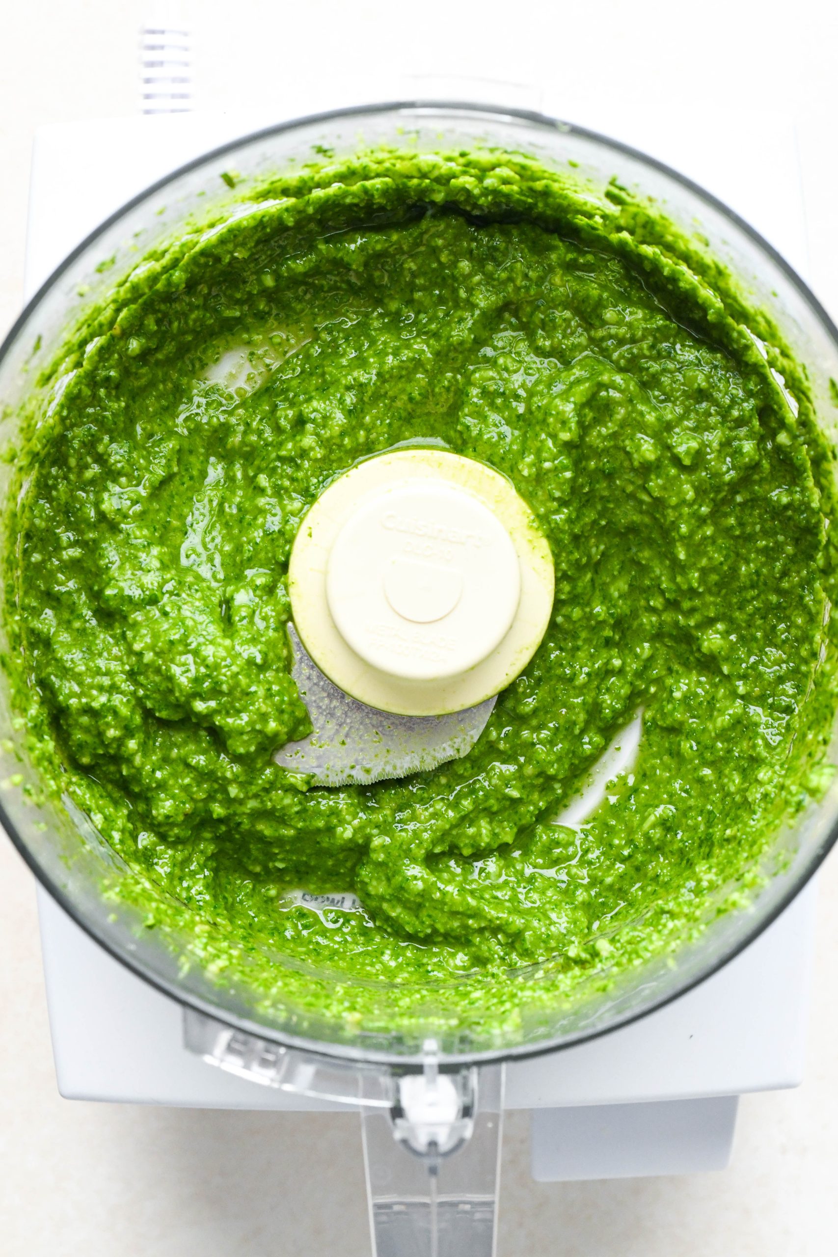 How to make homemade basil pesto: Finished creamy pesto in the bowl of food processor.