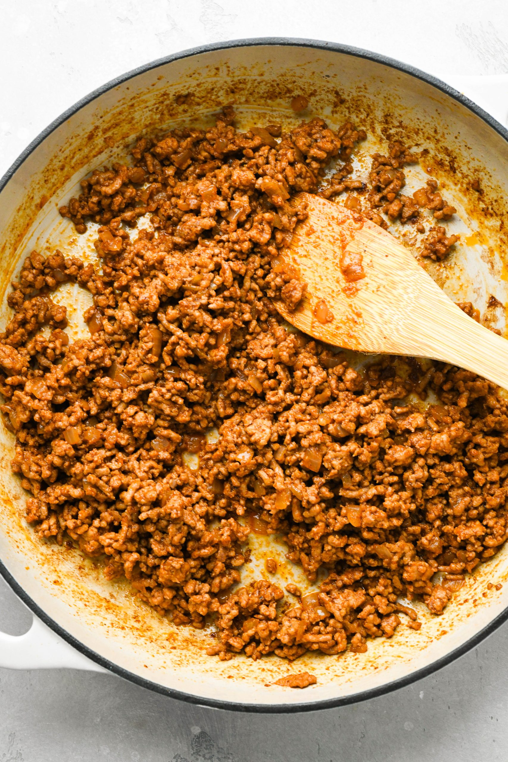 How to make ground pork tacos with creamy slaw: Ground pork in a skillet cooked with spices.