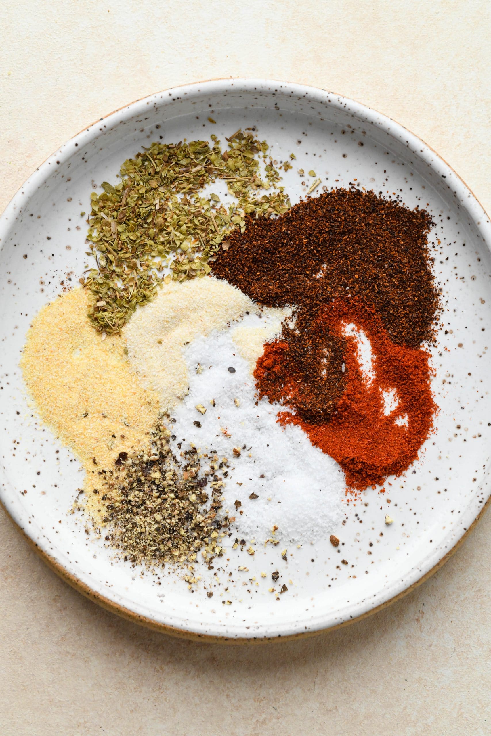 Blackening spices on a small white speckled plate.