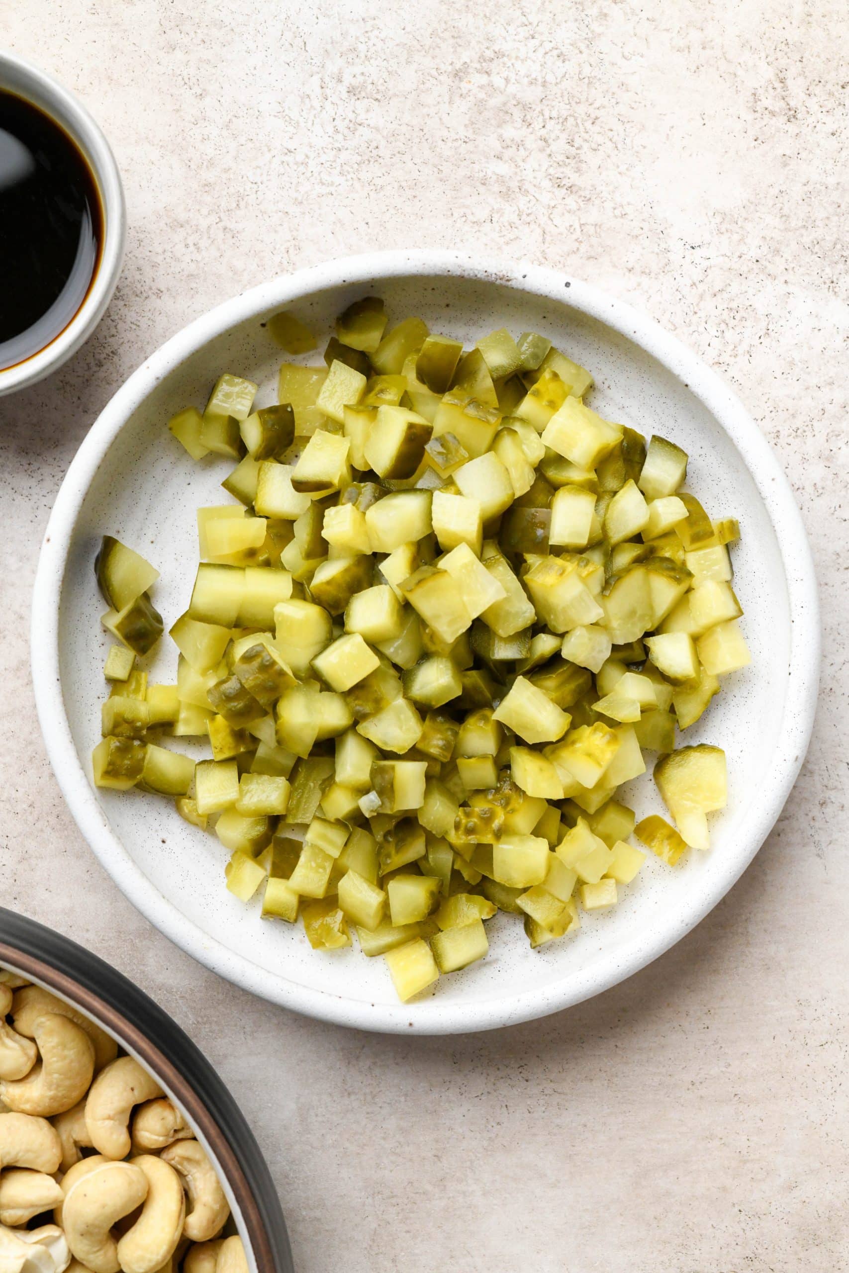Diced pickles in a small ceramic bowl for dill pickle dip.