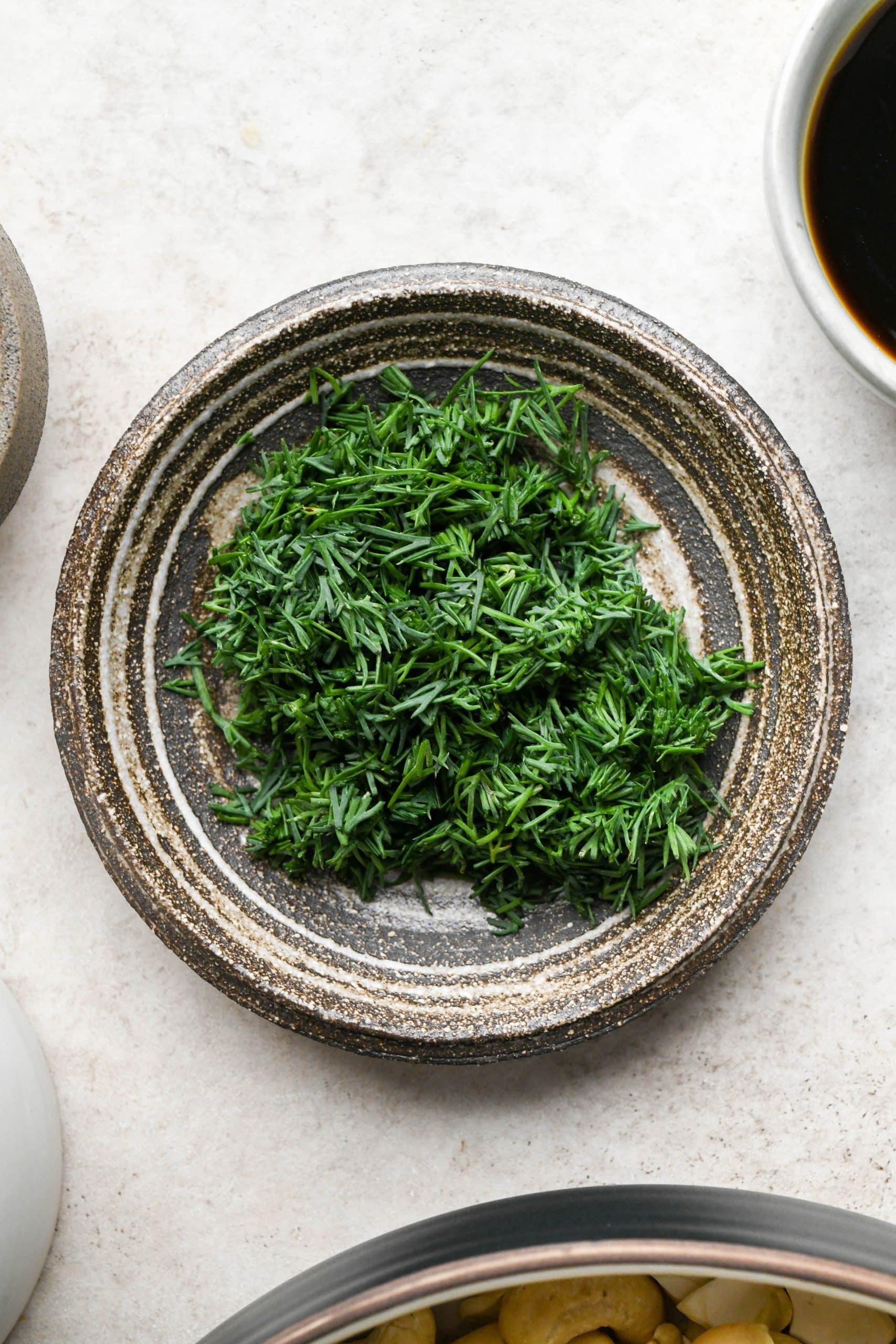 Chopped dill in a small ceramic dish for dill pickle dip.