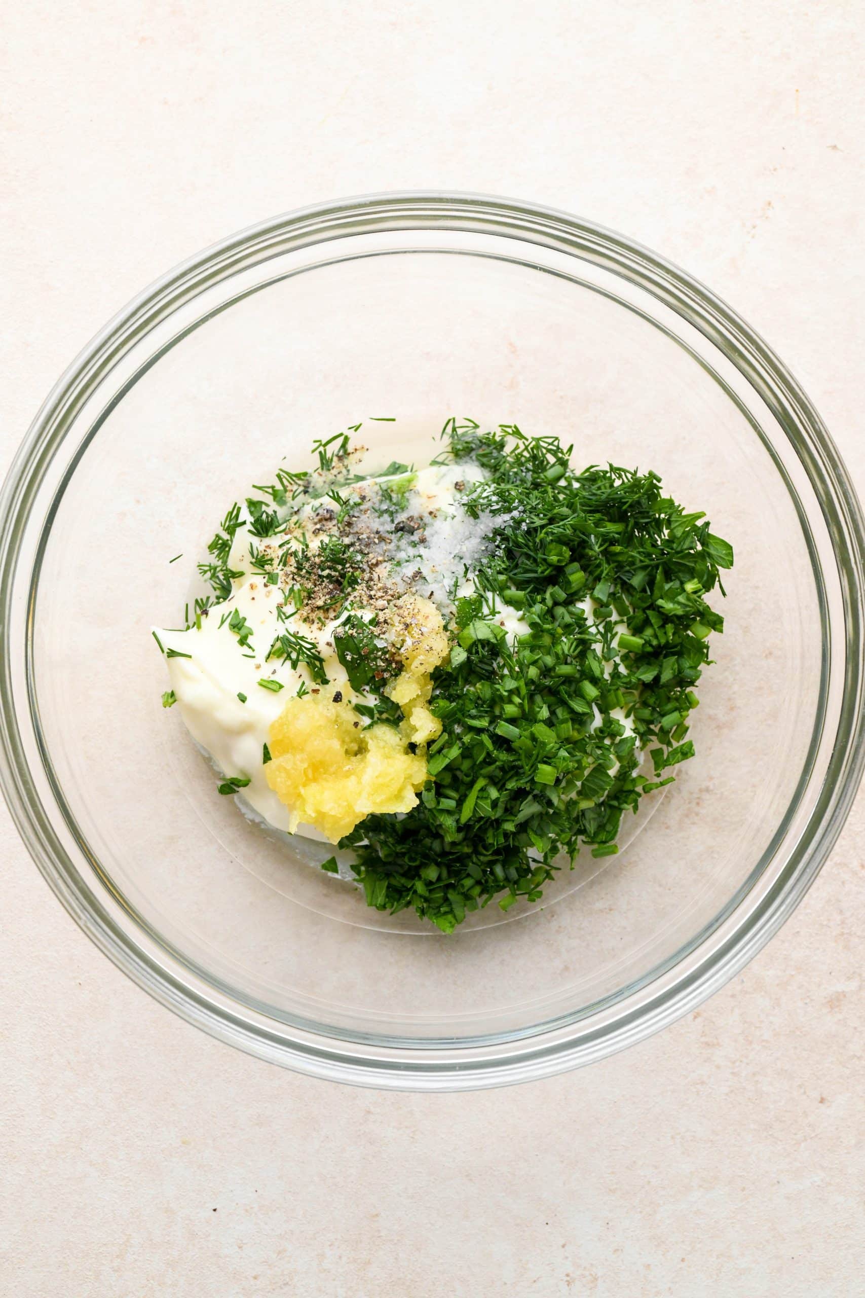 How to make Garlic Herb Aioli: Ingredients for aioli in a small glass bowl. 