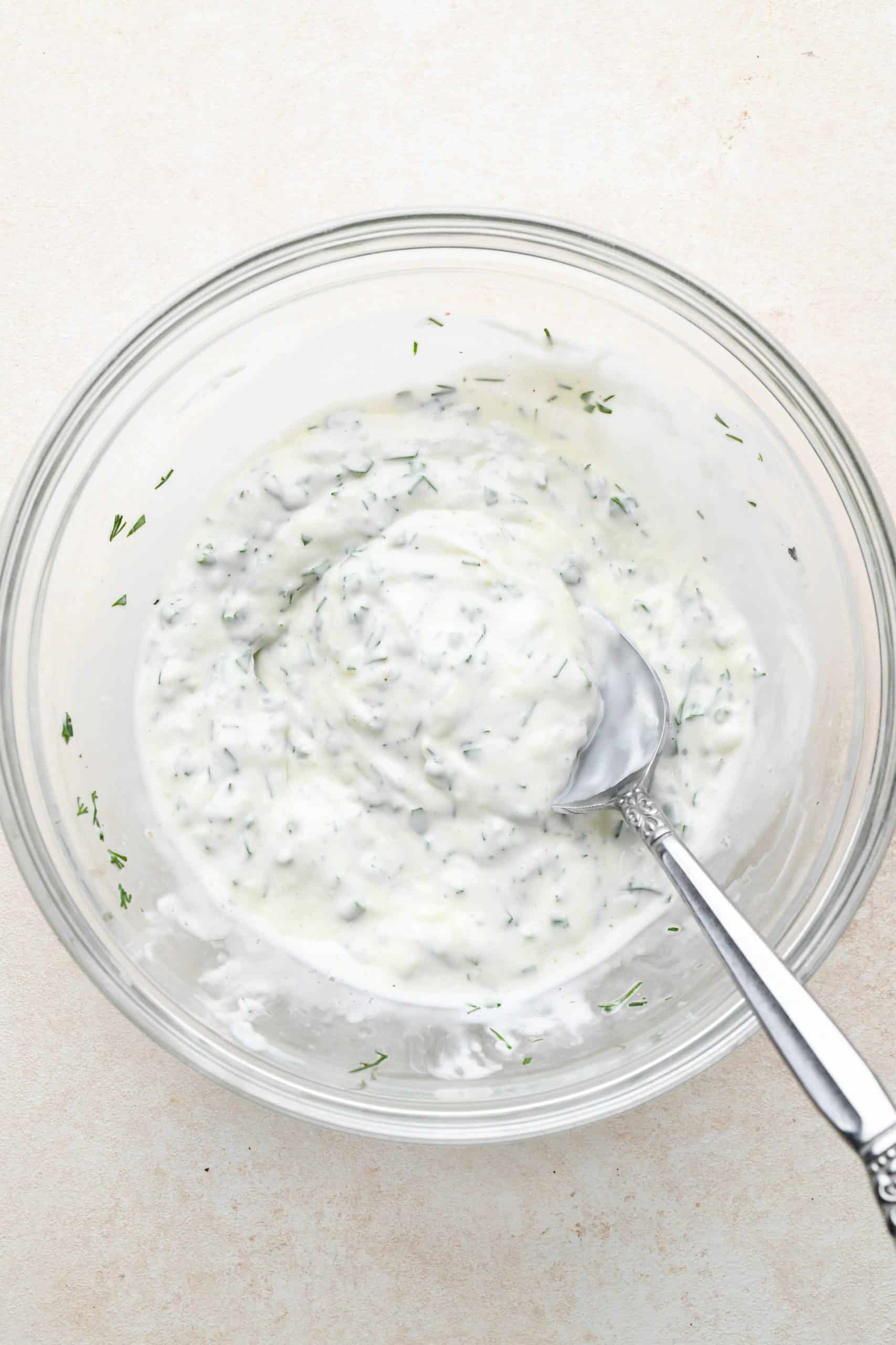 How to make Garlic Herb Aioli: Ingredients for aioli mixed together in a small glass bowl.