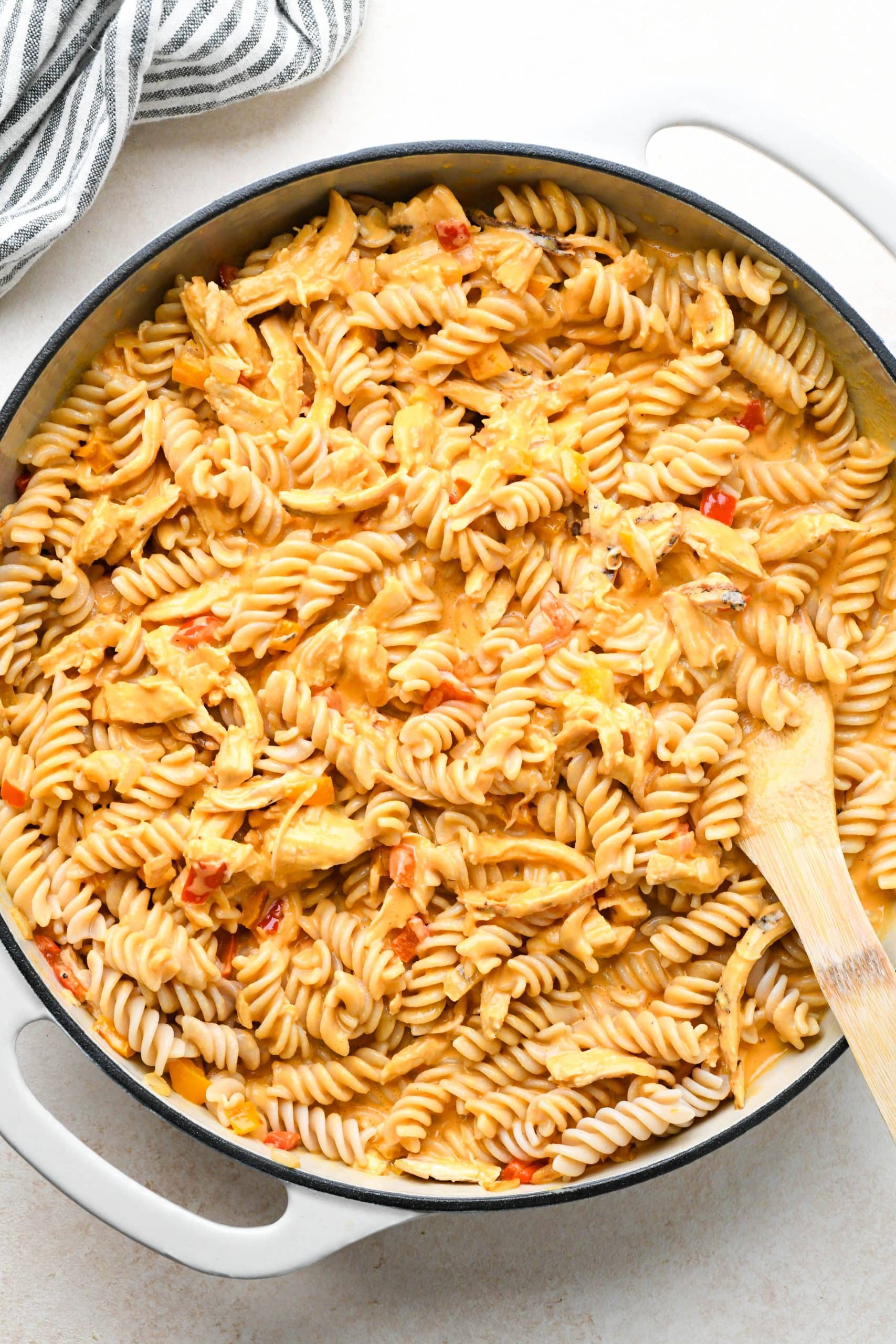 How to make buffalo chicken pasta: Finished pasta, noodles, veggies, and chicken coated with the spicy sauce in large skillet.