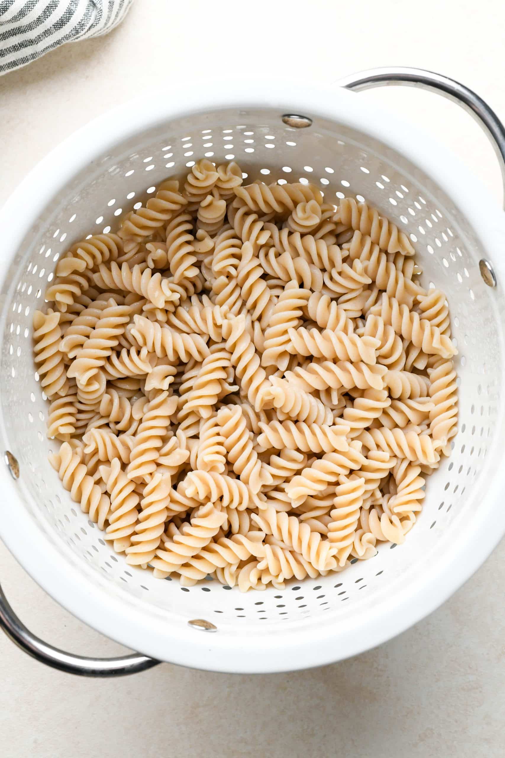 How to make buffalo chicken pasta: Gluten free pasta cooked and drained in a colander.