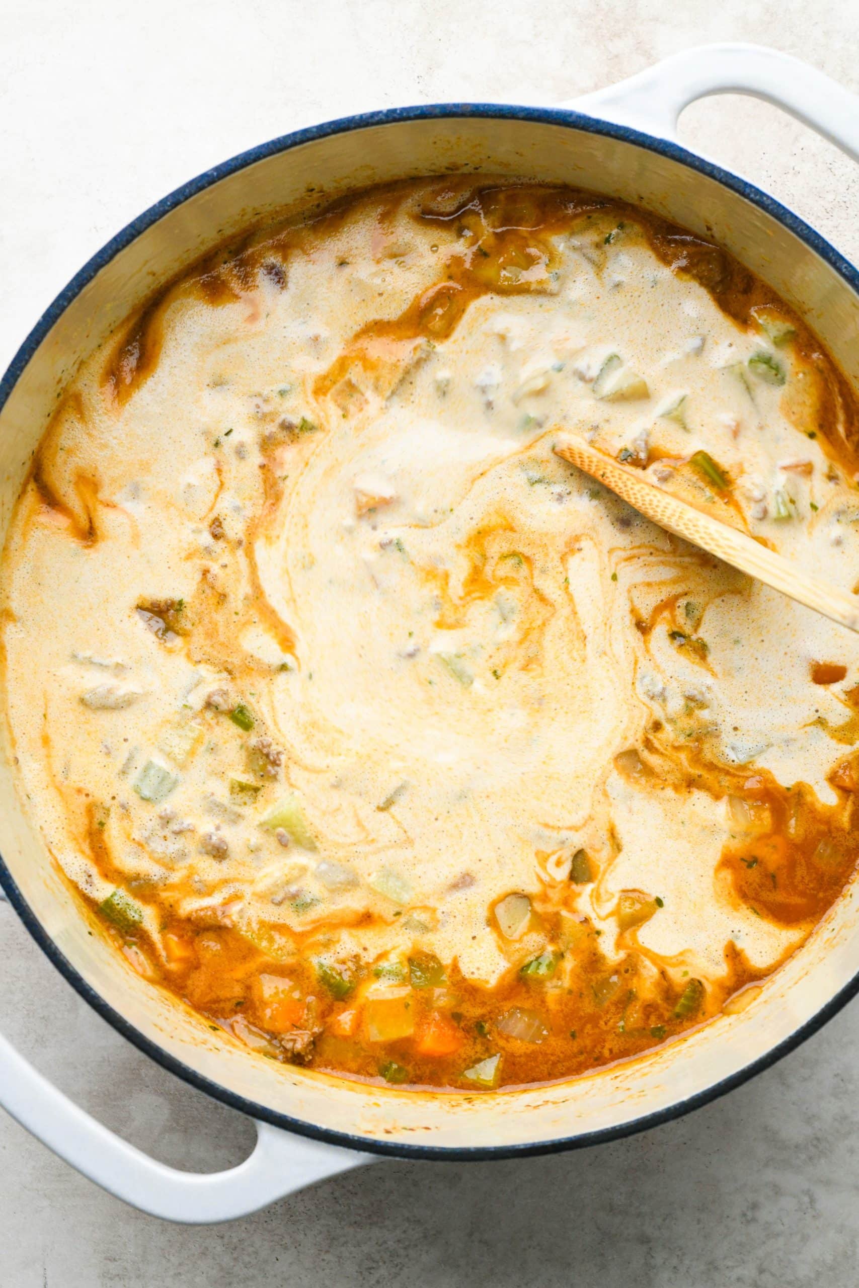 How to make shepherds pie soup: Stirring soup together with cashew cream.