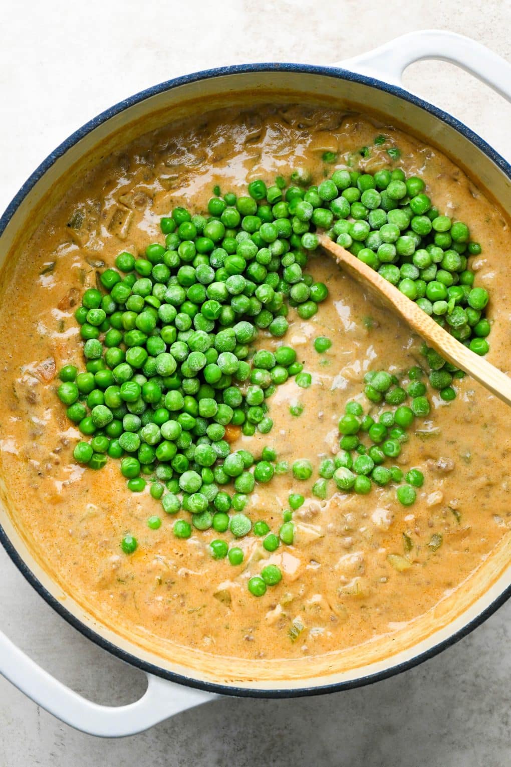 How to make shepherds pie soup: Stirring frozen peas into the soup.