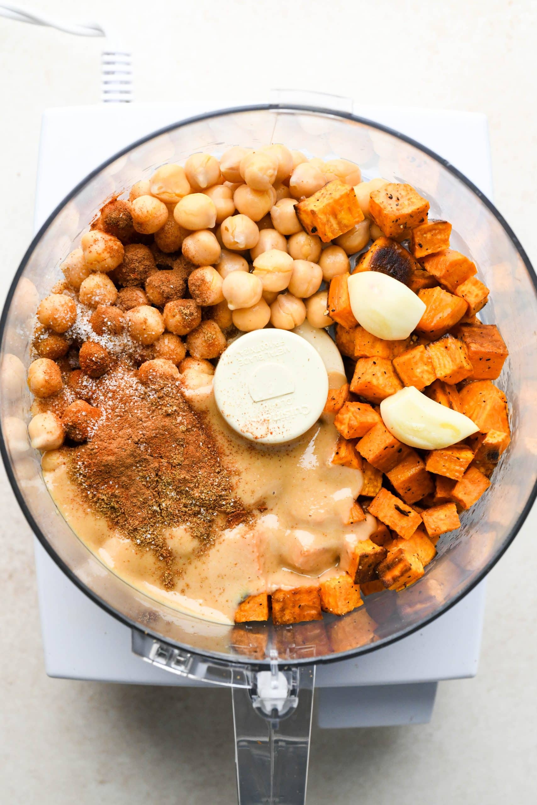 How to make Sweet Potato Hummus: Ingredients for hummus in the container of a food processor. 