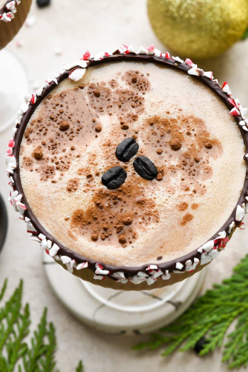 Overhead shot to show the top of a peppermint mocha espresso martini garnished with cocoa powder and coffee beans