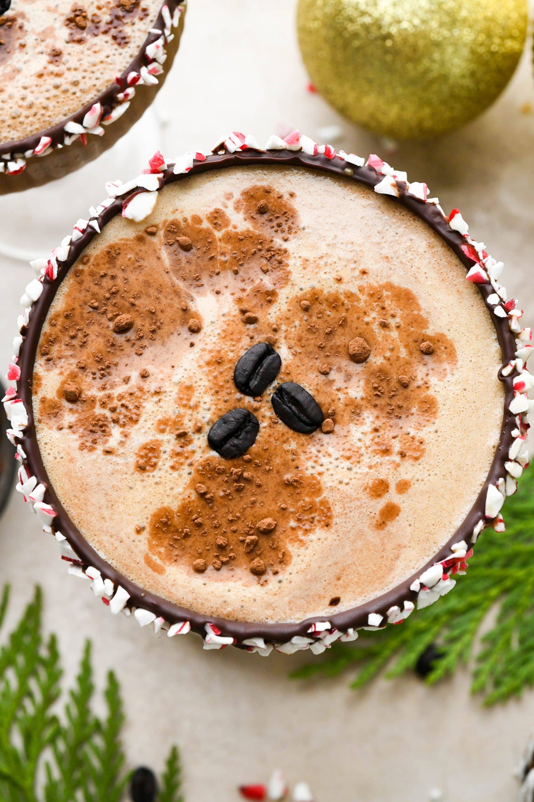 Overhead shot to show the top of a peppermint mocha espresso martini garnished with cocoa powder and coffee beans