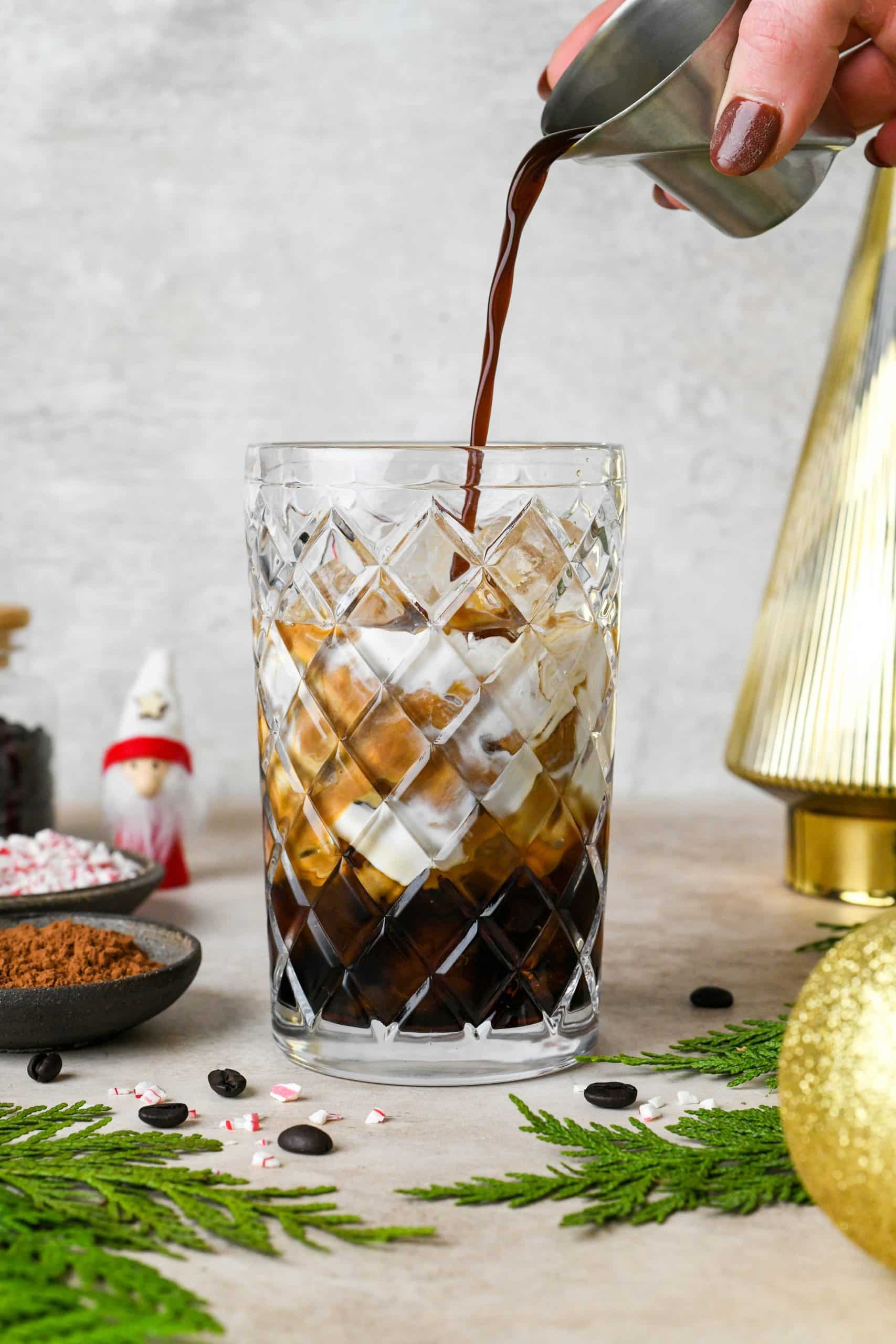 How to make Peppermint Mocha Espresso Martinis: Adding the espresso to an etched glass cocktail shaker filled with ice.