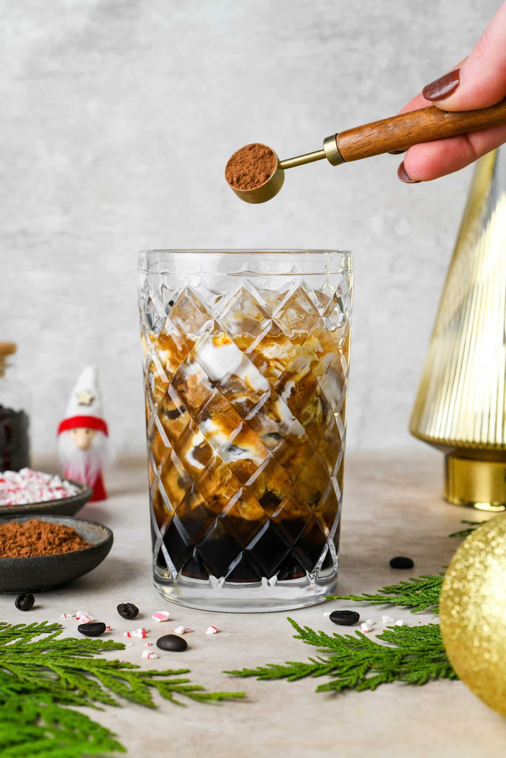 How to make Peppermint Mocha Espresso Martinis: Adding the cocoa powder to an etched glass cocktail shaker filled with ice.