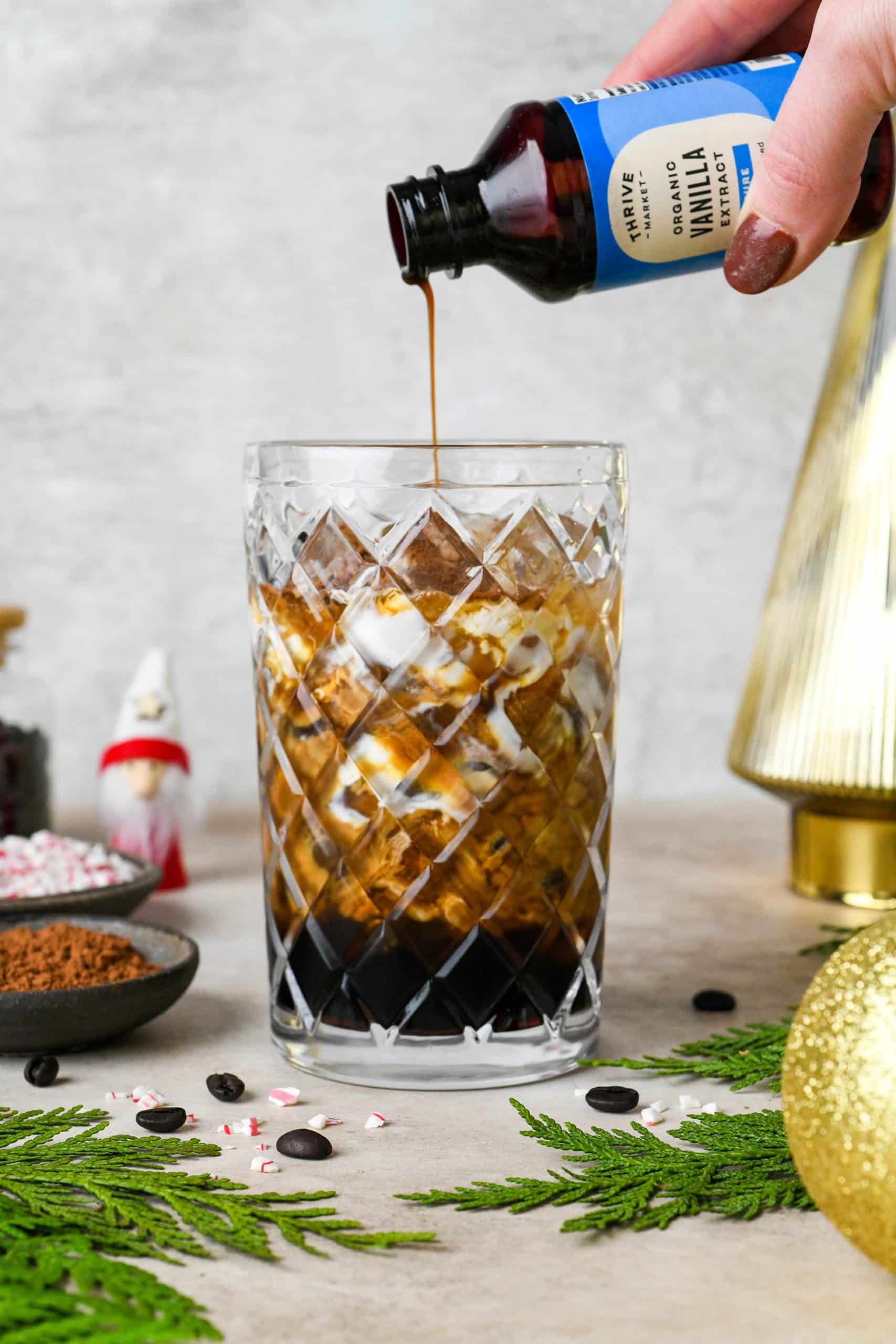 How to make Peppermint Mocha Espresso Martinis: Adding the vanilla extract to an etched glass cocktail shaker filled with ice.