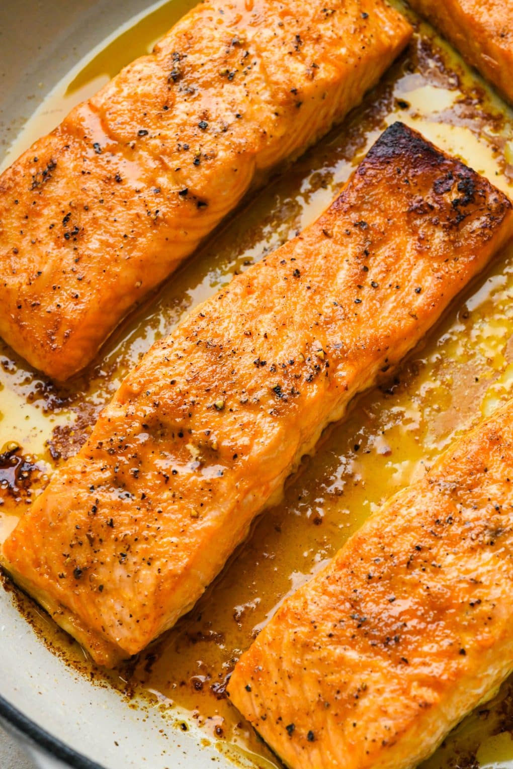 How to make baked buffalo salmon: Marinated salmon fillets in a round casserole skillet topped with salt and pepper - after baking.