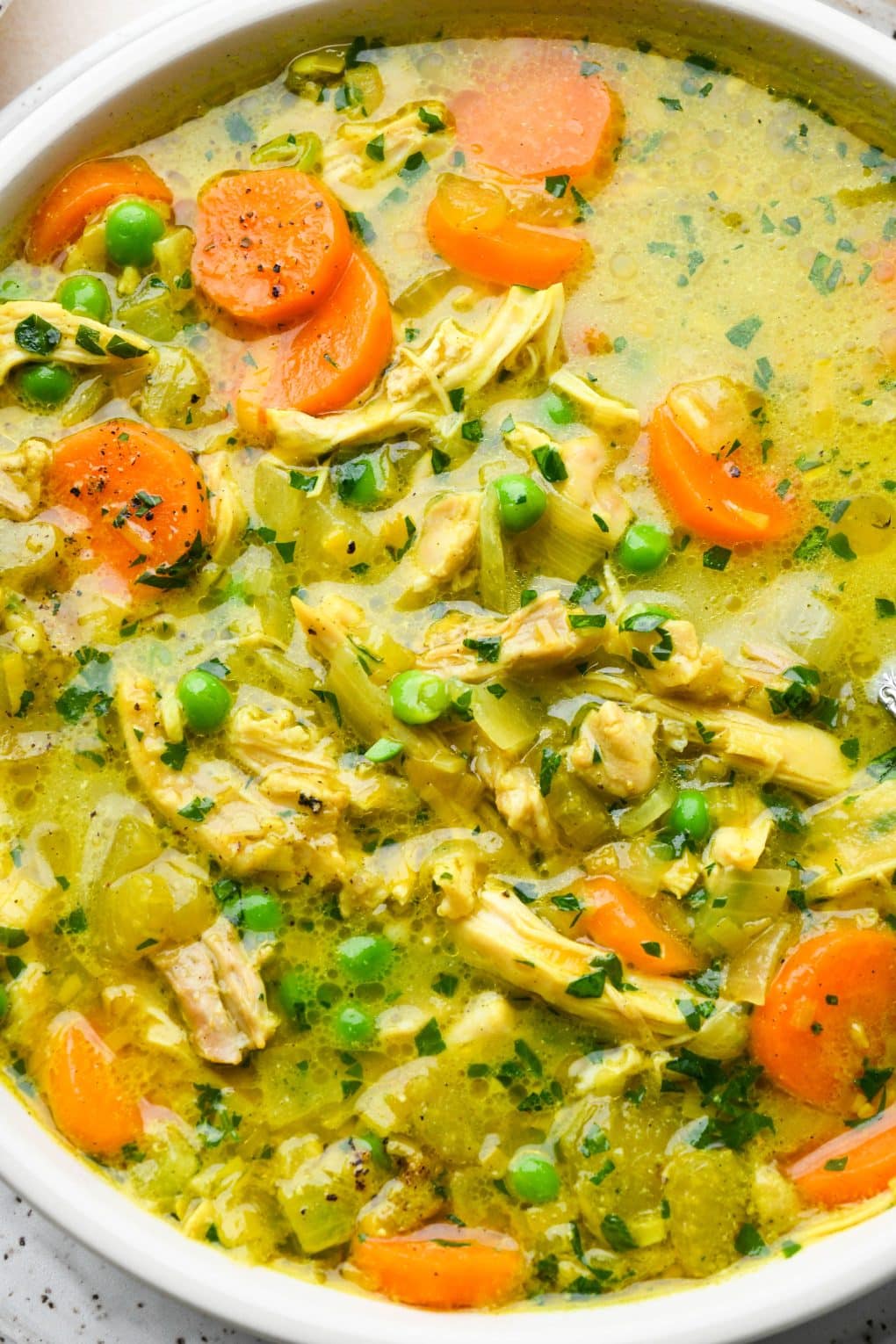 Close up image of vibrant, brothy, anti inflammatory chicken soup.