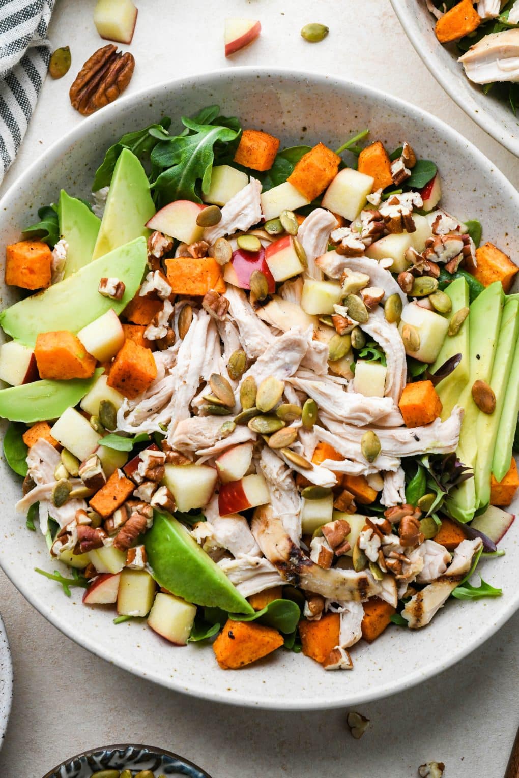 How to make Winter Chicken Salad: Salad ingredients assembled in a bowl after adding dressing, nuts, and seeds.