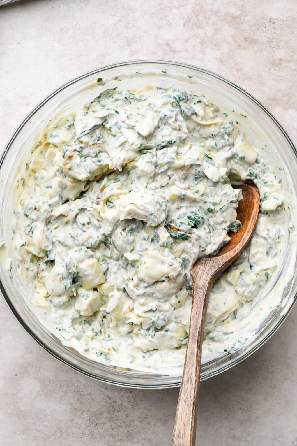 How to make Dairy Free Spinach Artichoke Dip: All dip ingredients mixed together in a glass bowl.