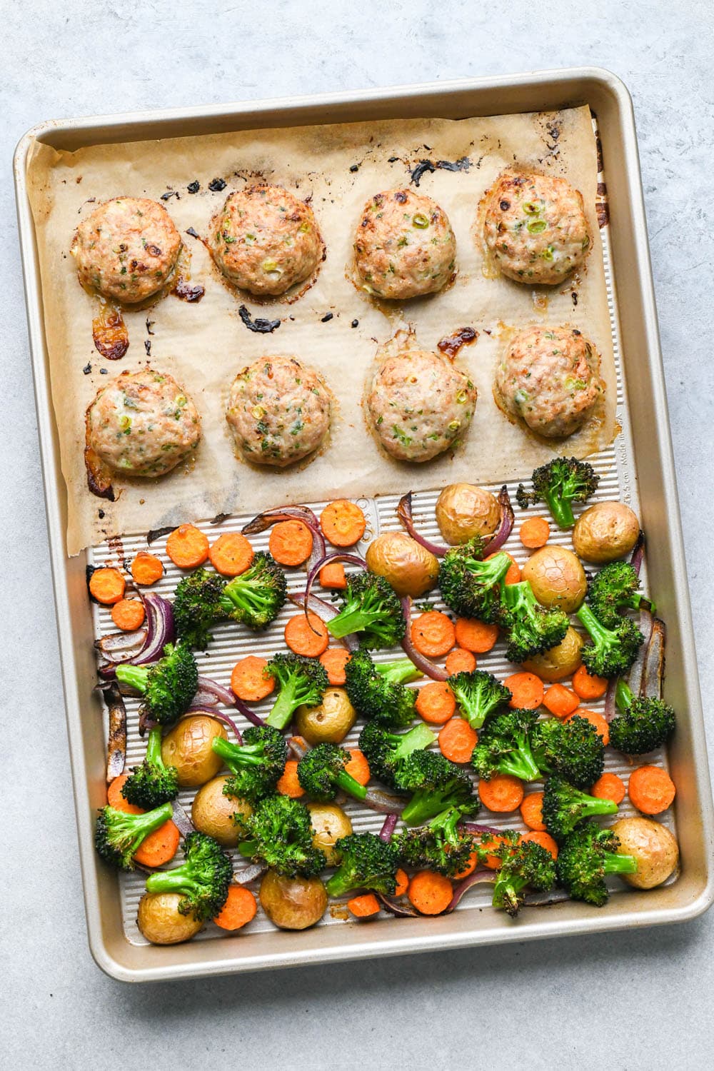How to make Roasted Veggie Protein Bowls with Turmeric Tahini: Chicken patties and veggies fully roasted on a sheet pan. 