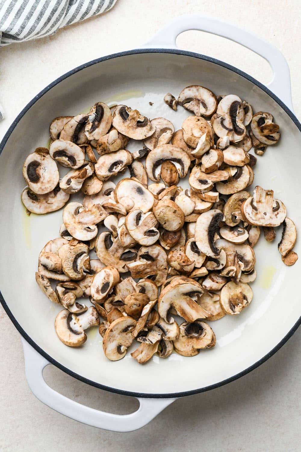 How to make Creamy Tomato Sausage Pasta: Raw mushrooms in skillet with olive oil. 