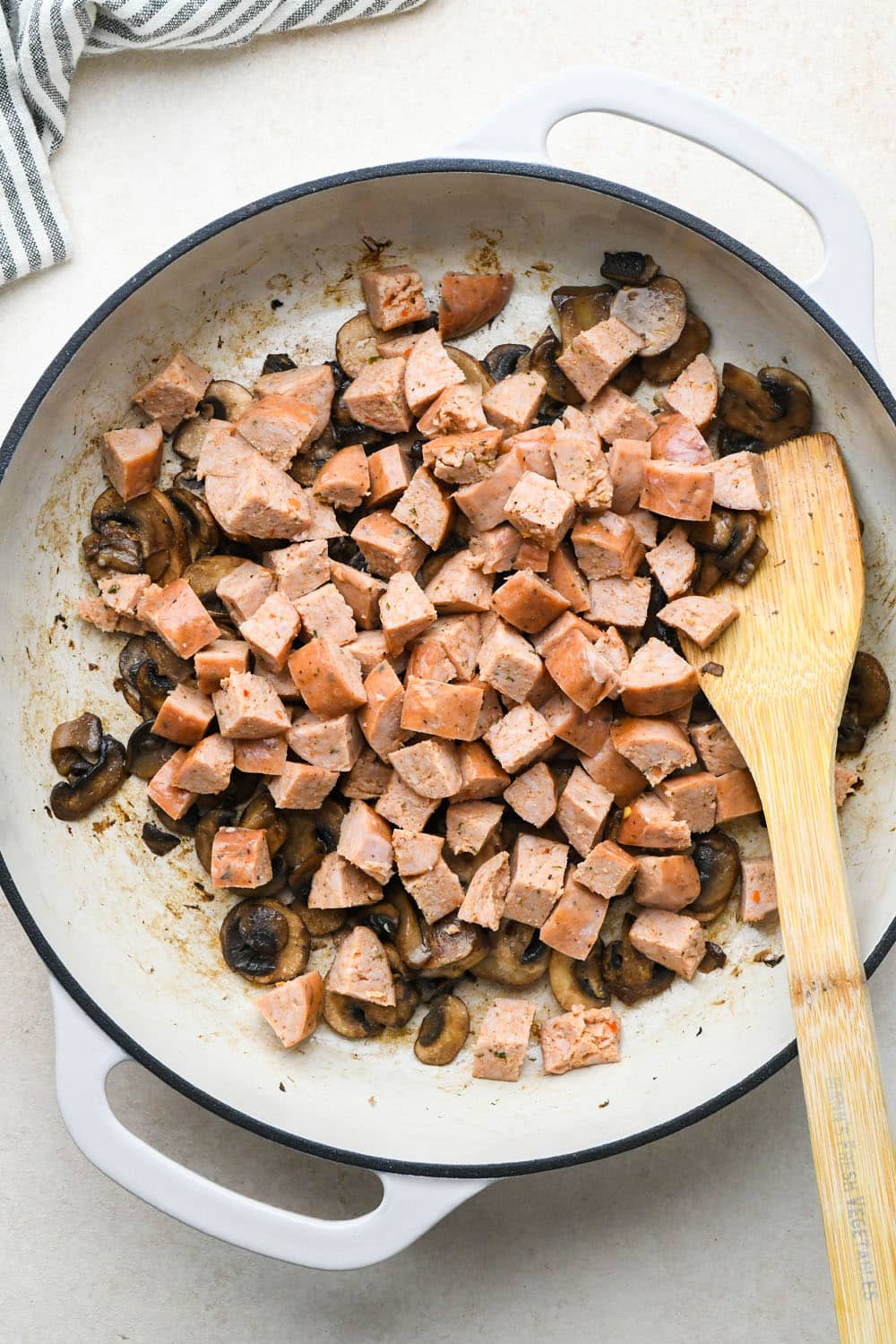 How to make Creamy Tomato Sausage Pasta: Cooked mushrooms in skillet with sausages added.