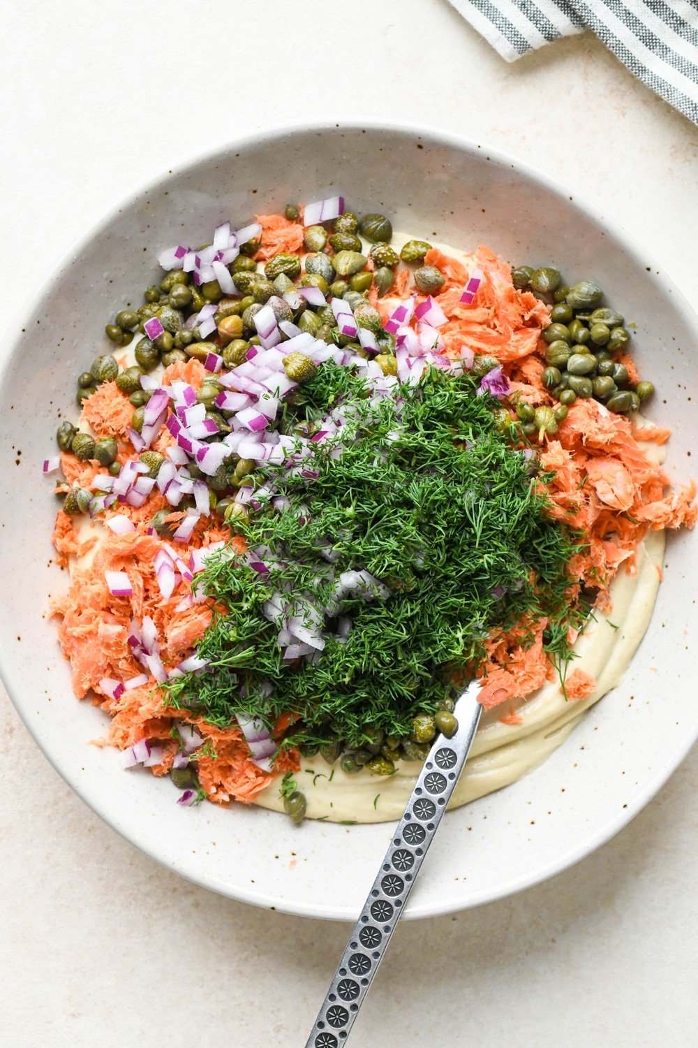 How to make dairy free smoked salmon dip: Smoked salmon, red onion, dill, and capers added to the cashew cream base.