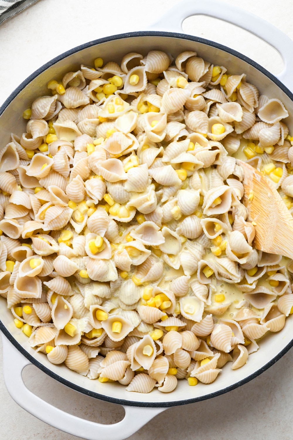 How to make Creamy Dairy Free Corn Pasta with Basil: Stirring pasta to combine with sauce.