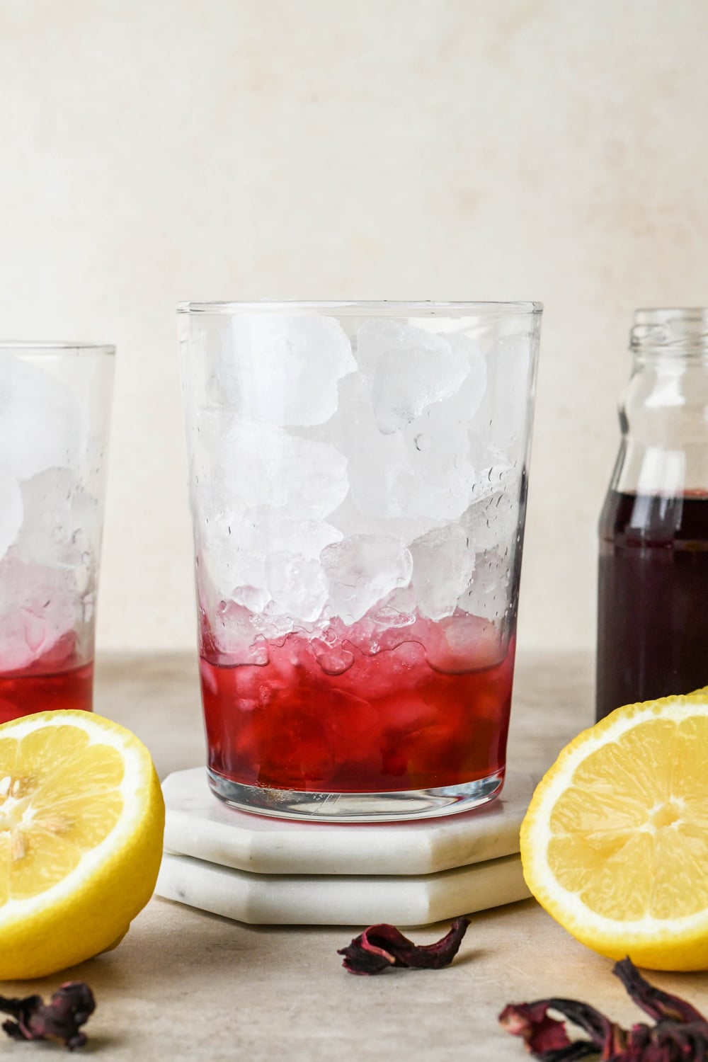 How to make hibiscus lemonade: Hibiscus concentrate and lemon juice in a glass with ice.